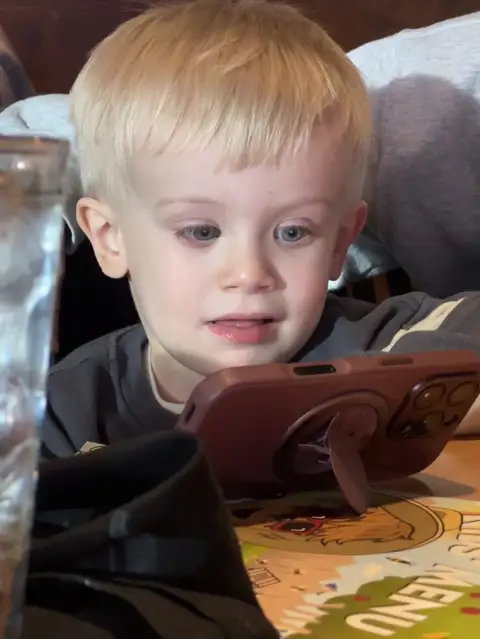 Captivated by the screen.